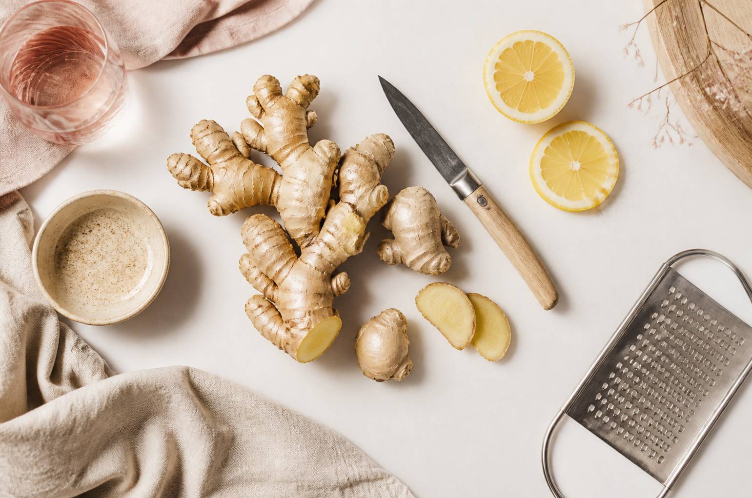Racines de gingembre frais avec citron et râpe sur plan de travail