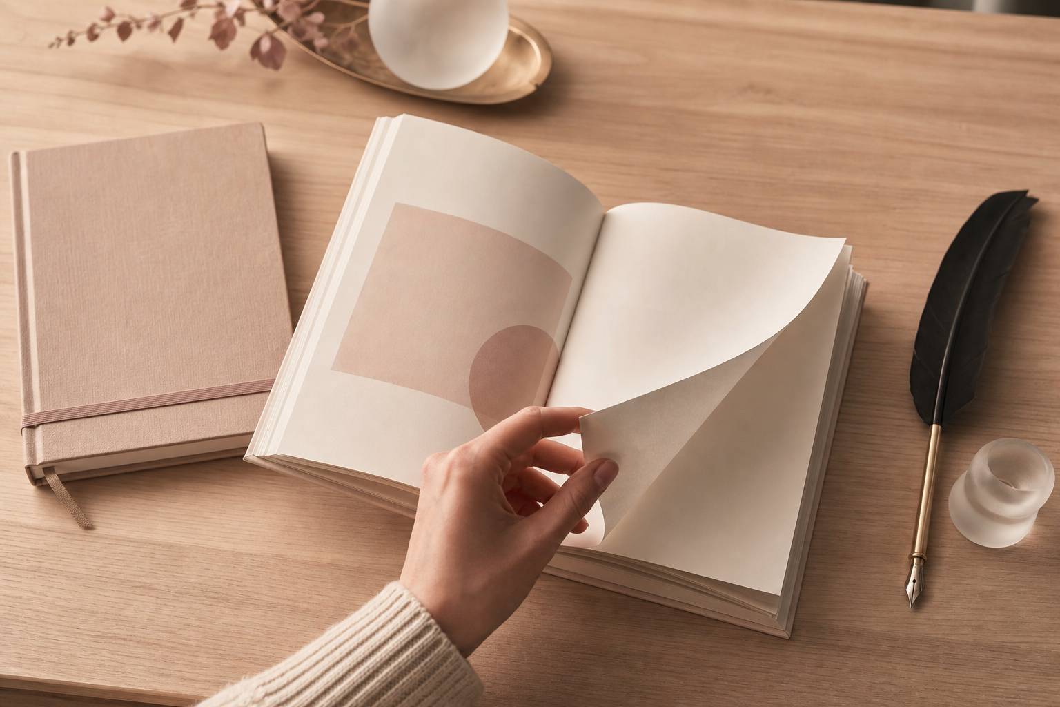 Main tournant une page d'un recueil de poèmes sur table en bois clair avec plume à encre